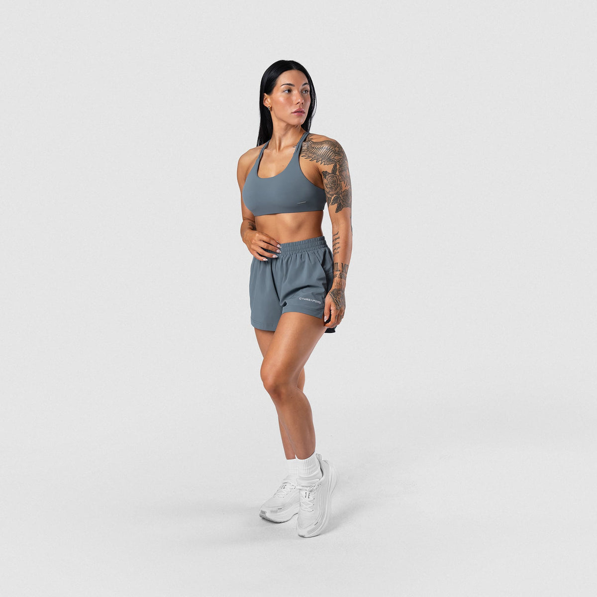 Female model wearing the Axis Sport Shorts - Lake full-body front view