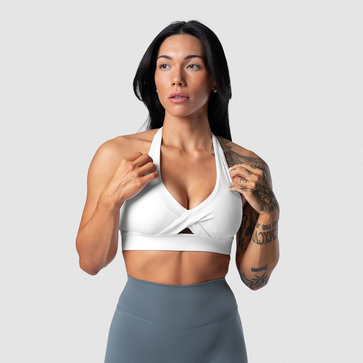 Female model wearing the Axis Twisted Halter Bra - White front view