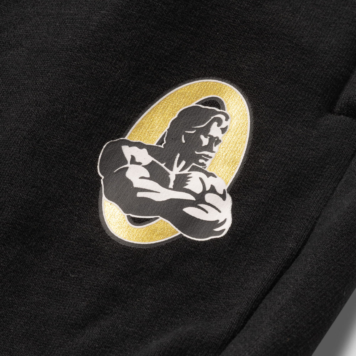 Close up of embroidered Olympia logo featuring the Gold "O"