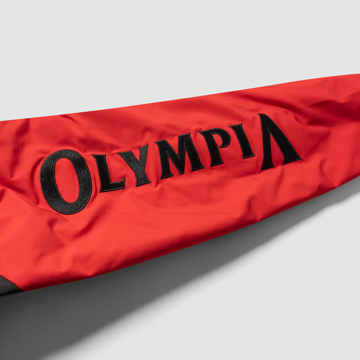 Signature Crop Bomber Jacket | Red sleeve close up feature, showcasing the black, stitched "Olympia" wordmark