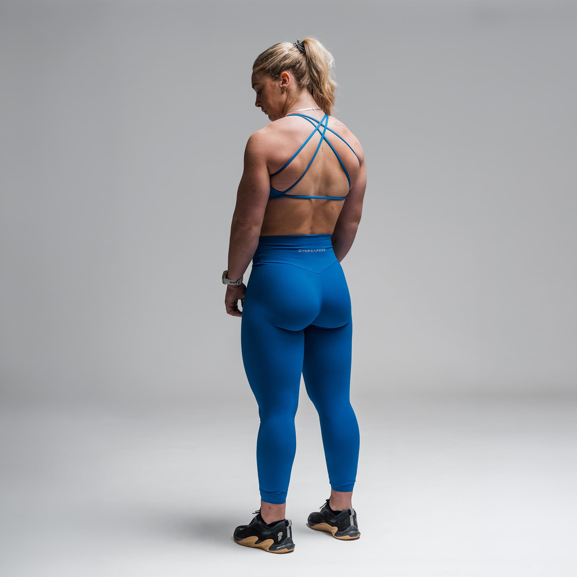 Athlete wearing the Electric Blue Axis Leggings full body shot back view
