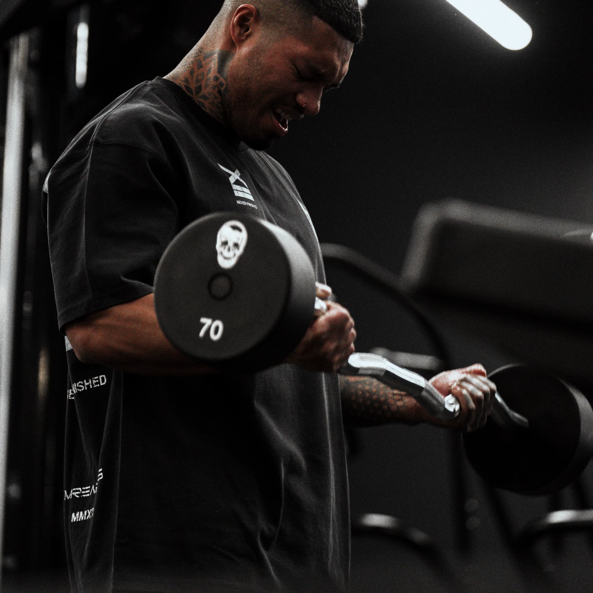 Athlete doing bicep curls while wearing 12th Anniversary Tee - Never Finished