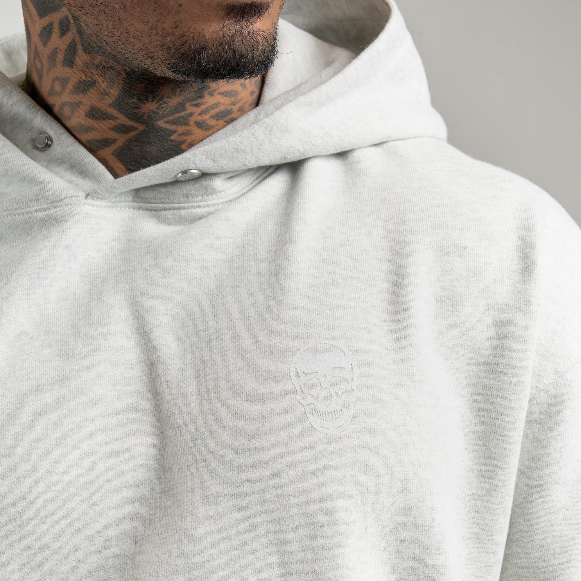 athlete wearing Light Heather Gray Heavyweight Hoodie close up shot of skull detail