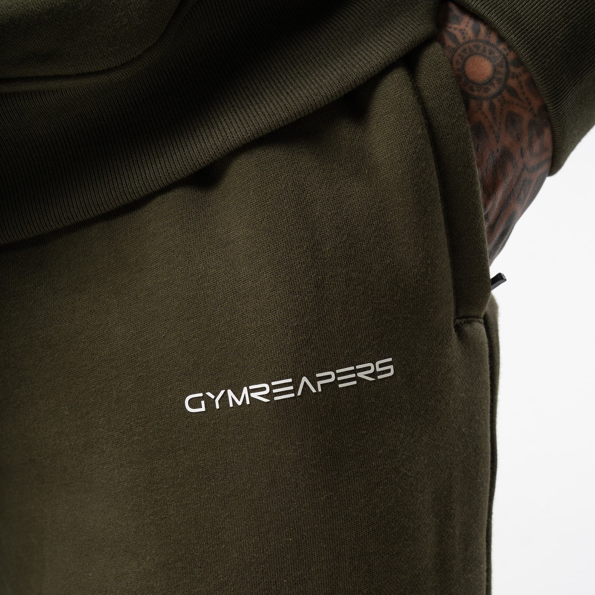 athlete wearing green axis joggers close up detail shot of logo