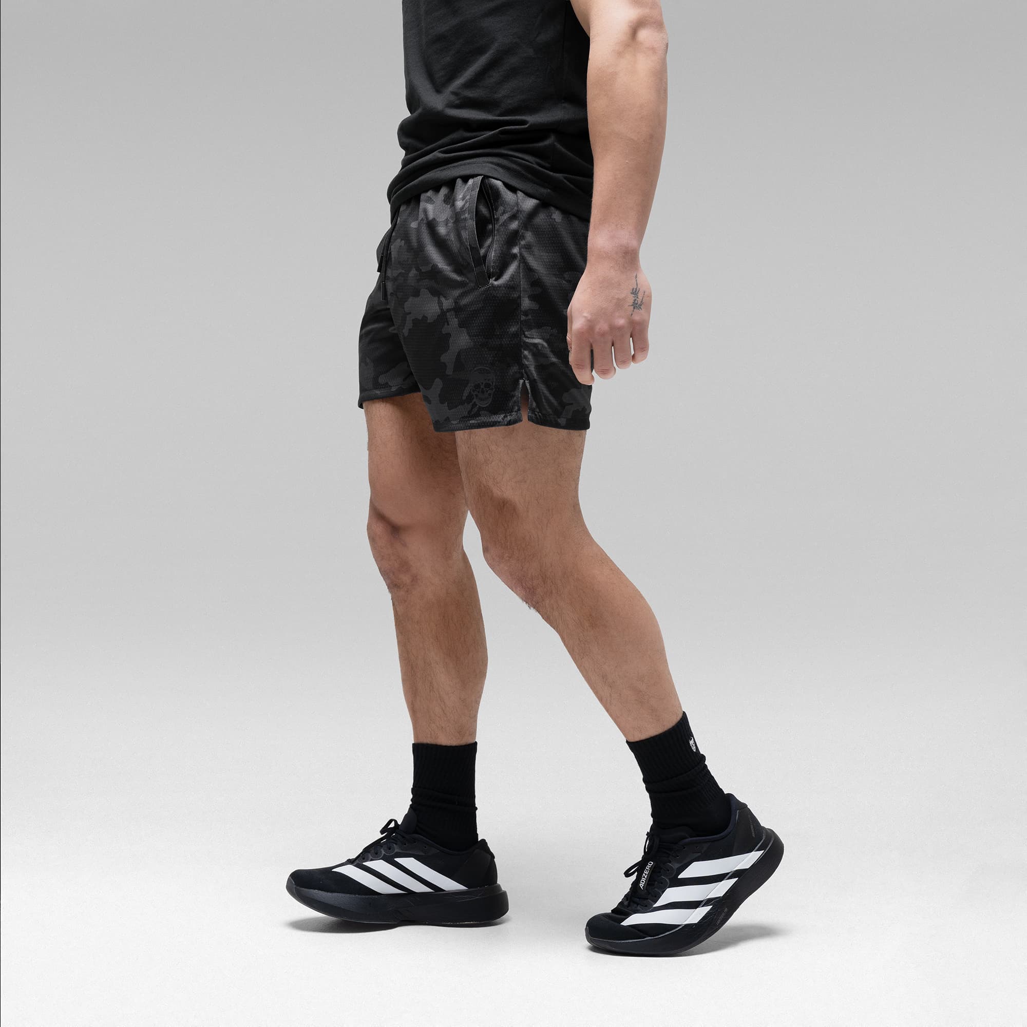 Athlete wearing the Black Camo Core Skull Mesh Training Shorts half body shot