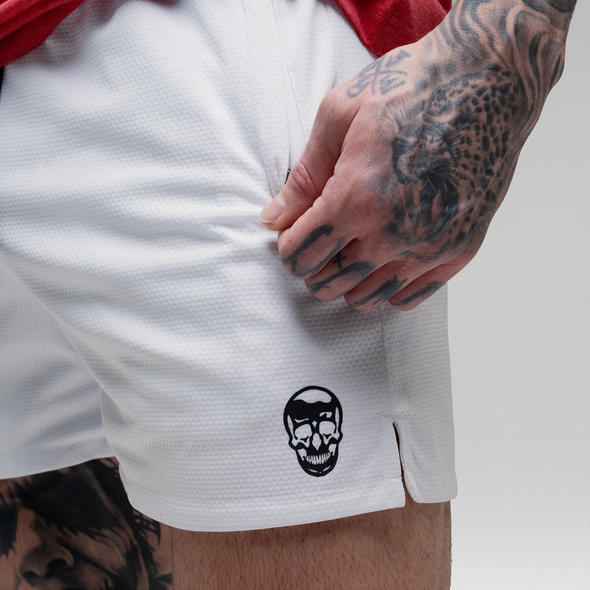 Athlete wearing the White Core Skull Mesh Training Shorts detail shot of logo