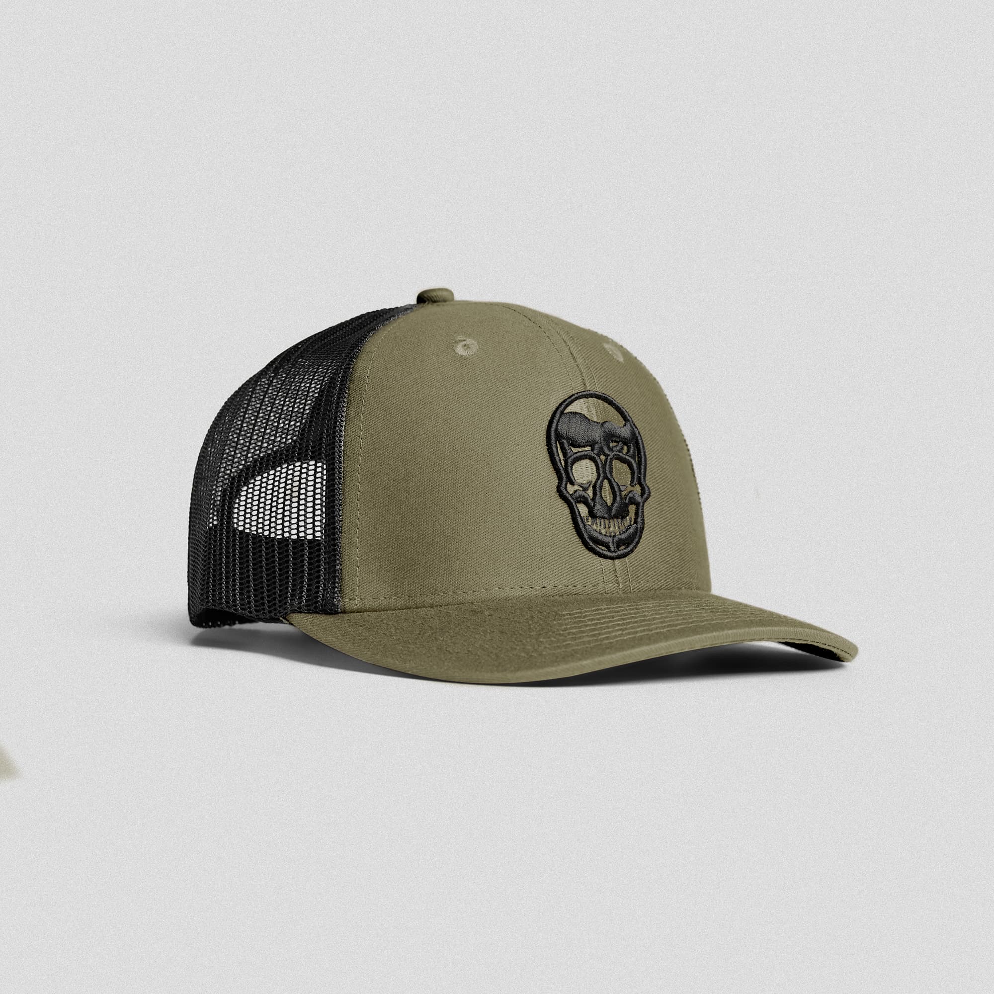 Front view of Gymreapers olive trucker hat with embroidered skull logo