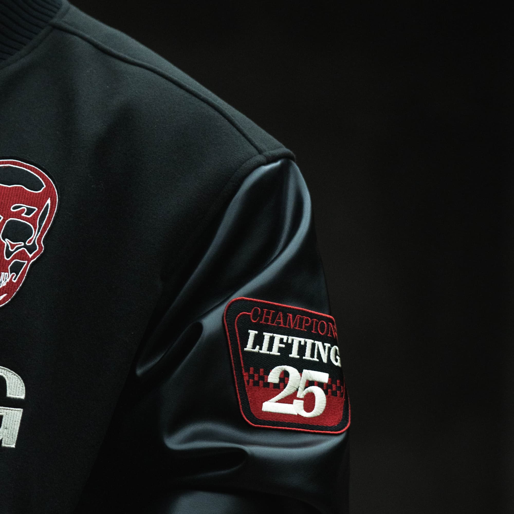 Close-up of the sleeve patch on the Racing Team Varsity Jacket with “Champion Lifting 25” embroidery.