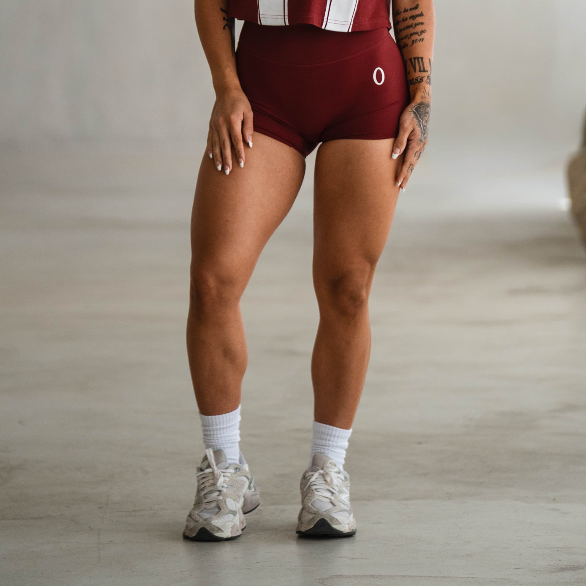 Model wearing the Olympia 4" Training Shorts, showcasing the front high-rise fit with subtle O logo detail.