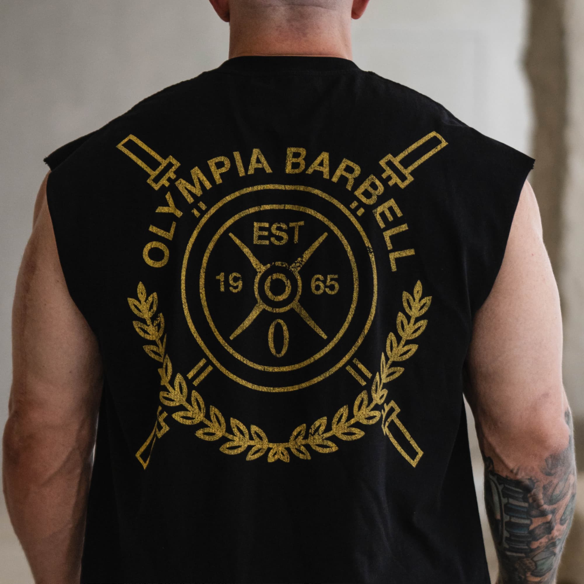 close up lifestyle shot of athlete wearing crest cut off showcasing back graphic