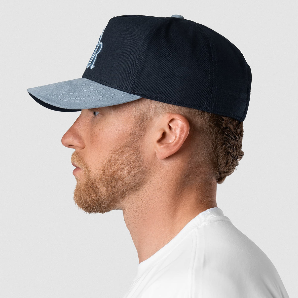 Male model wearing the 5-Panel Initial Suede Hat - Blue left side view