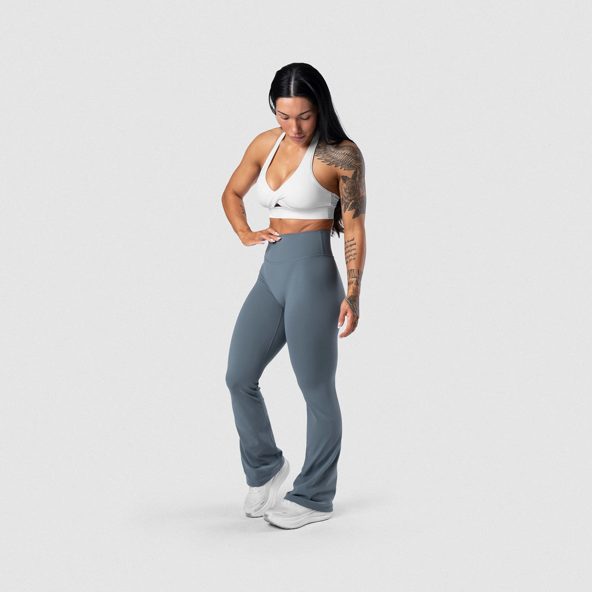 Female model wearing the Axis Flare Leggings - Lake full-body angled view