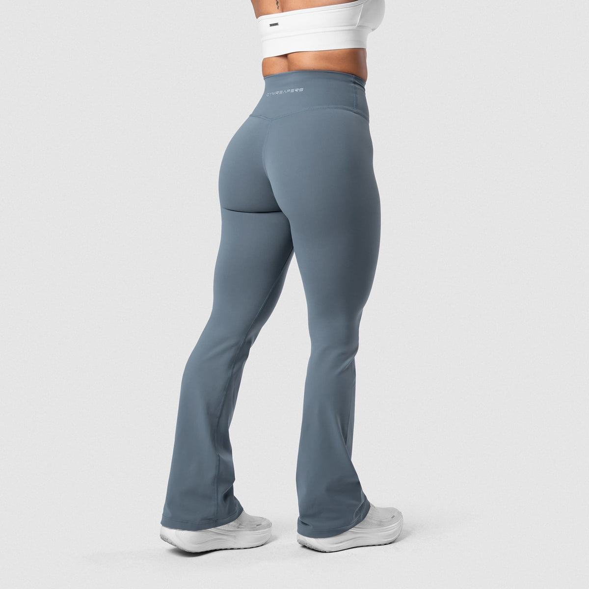 Female model wearing the Axis Flare Leggings - Lake back view