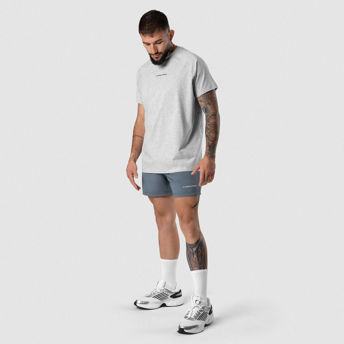 Male model wearing the Axis Raglan Tee - Heather Gray full-body view