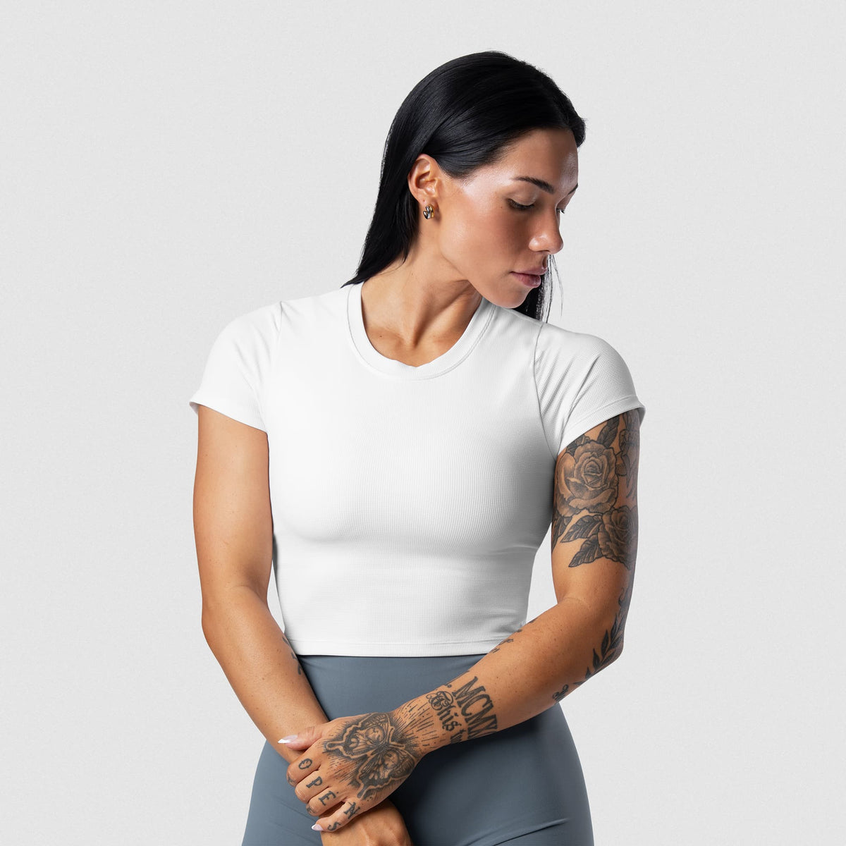 Female model wearing the Axis Support Baby Tee - White front view