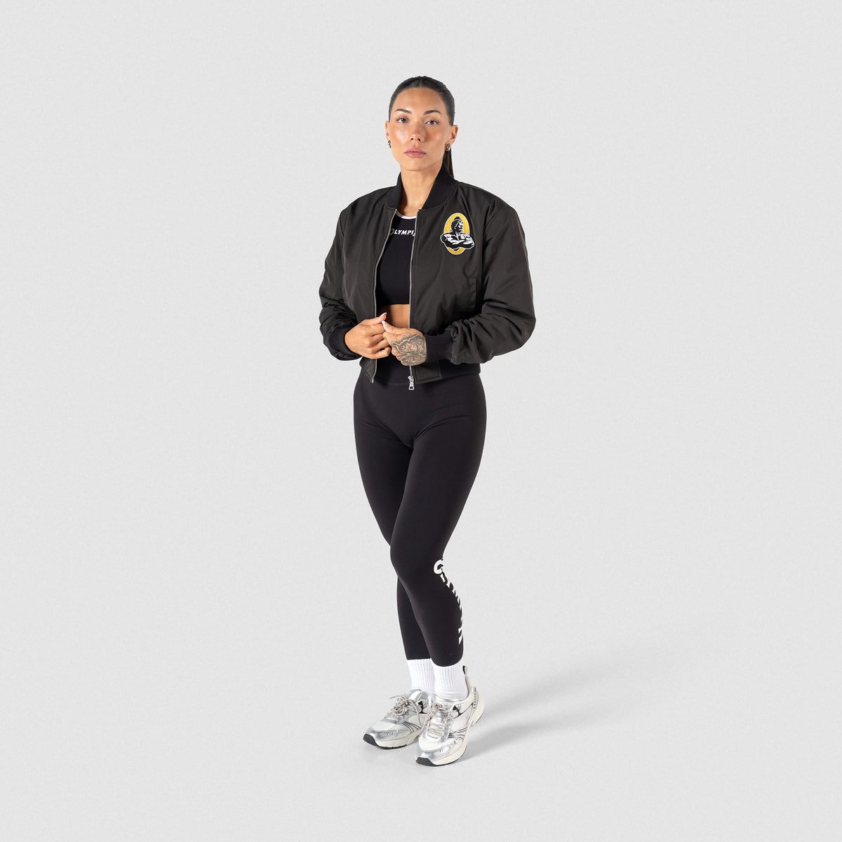 Champions Gold Crop Bomber Jacket | Full body view of model wearing the Champions Gold jacket with matching Olympia Leggings