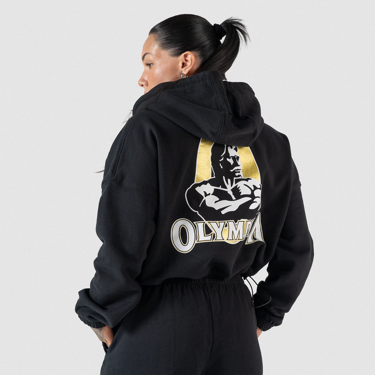Champions Gold Cropped Zip-Up Hoodie |  Back view, on model showcasing the large Gold and White Olympia Logo