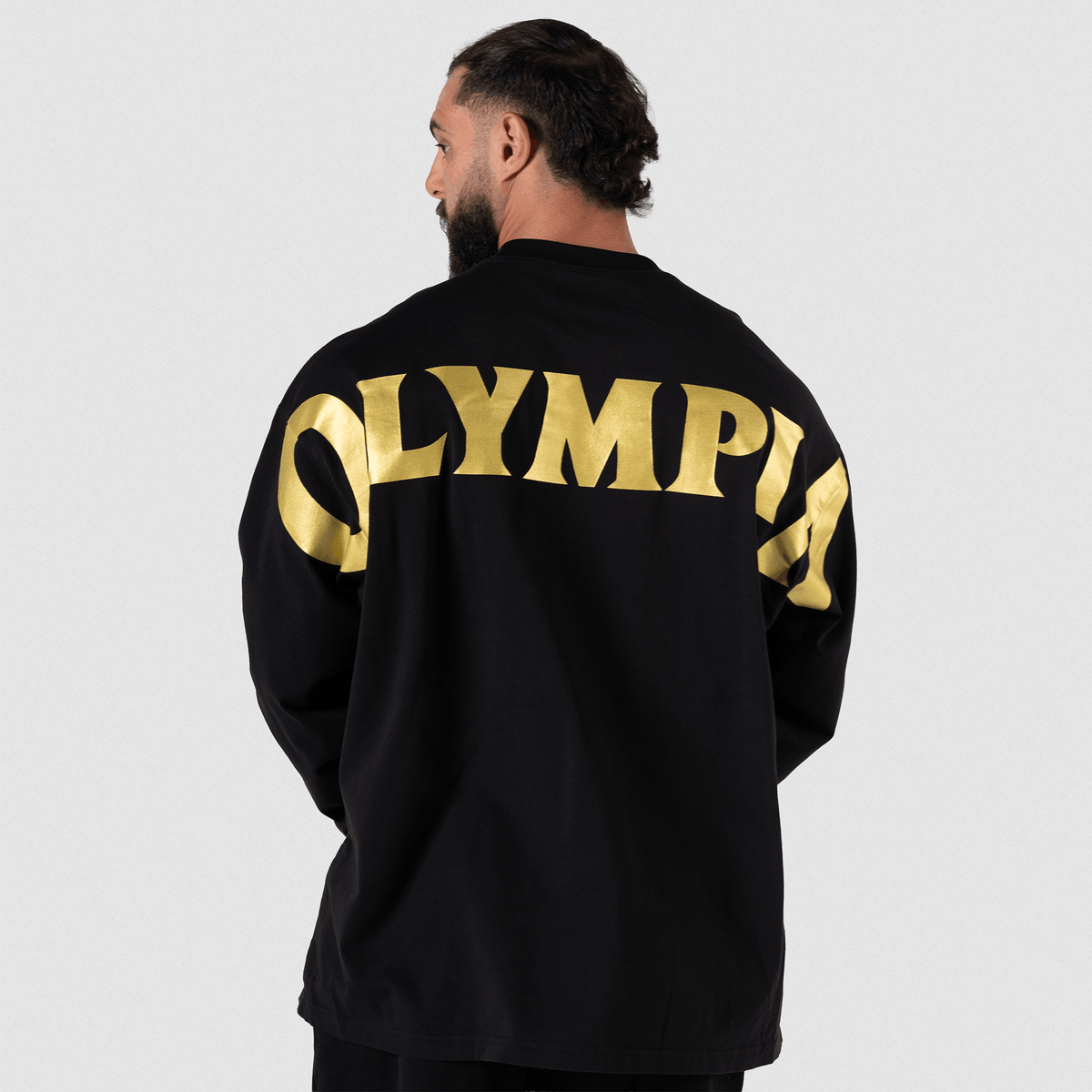 Man wearing black long-sleeve top with gold 