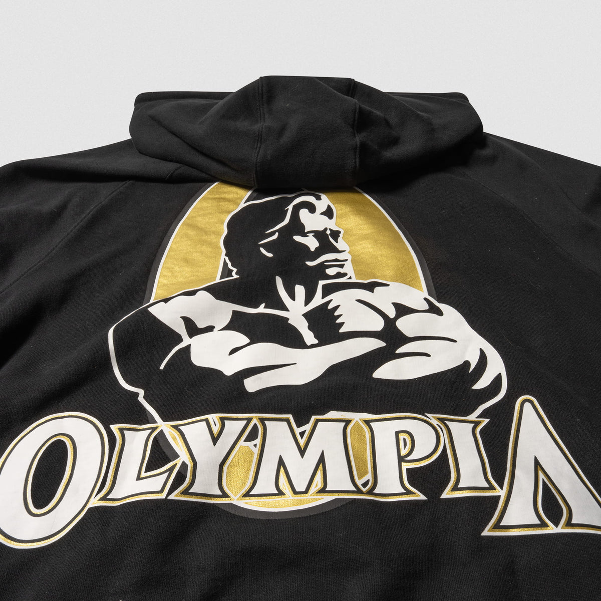 Champions Gold Zip-Up Hoodie | Large back graphic of official Champions Gold Olympia event logo in black, white, and gold