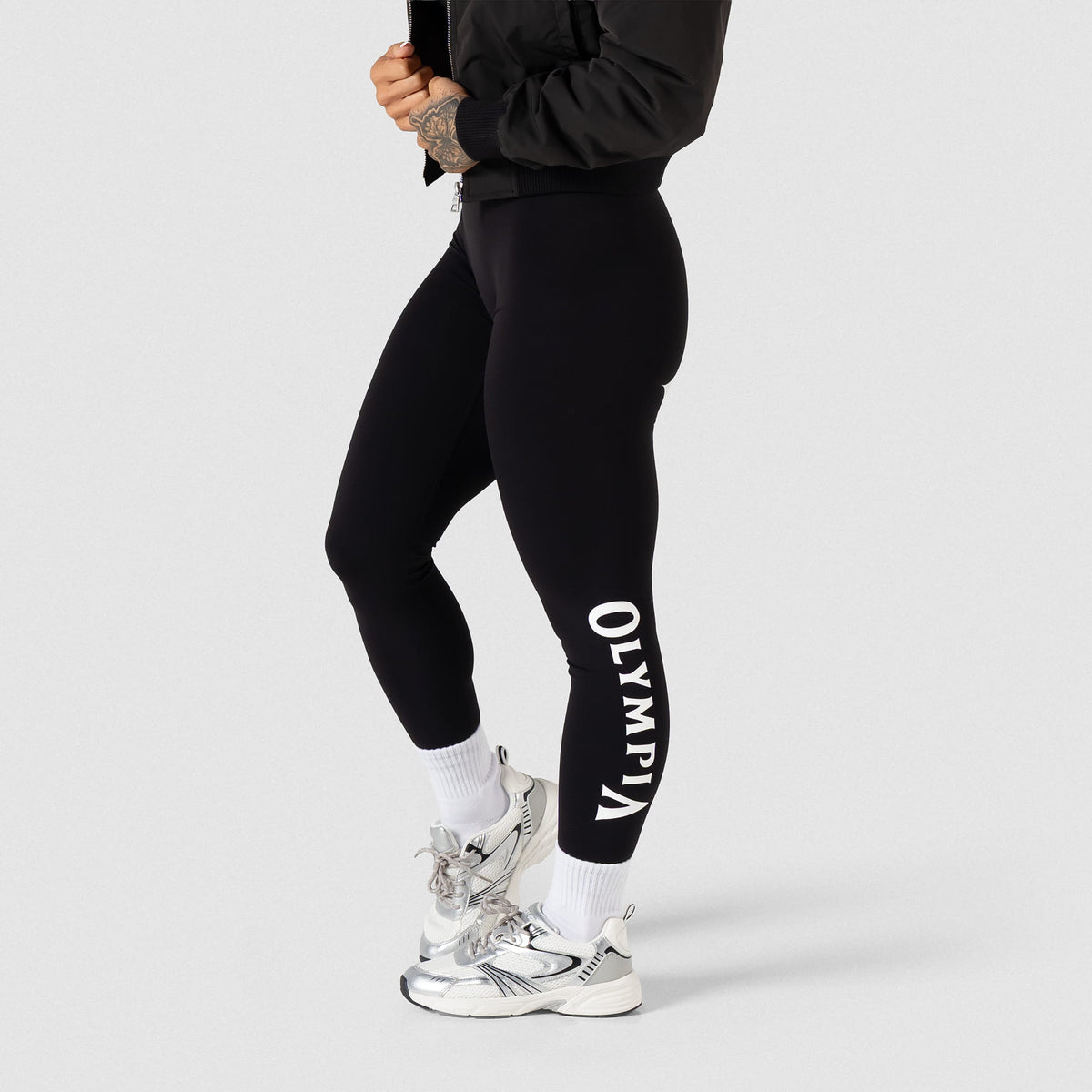 Side view of the Women's Olympia Legging in Black showing the "Olympia"  wordmark text in black along the side of the calf