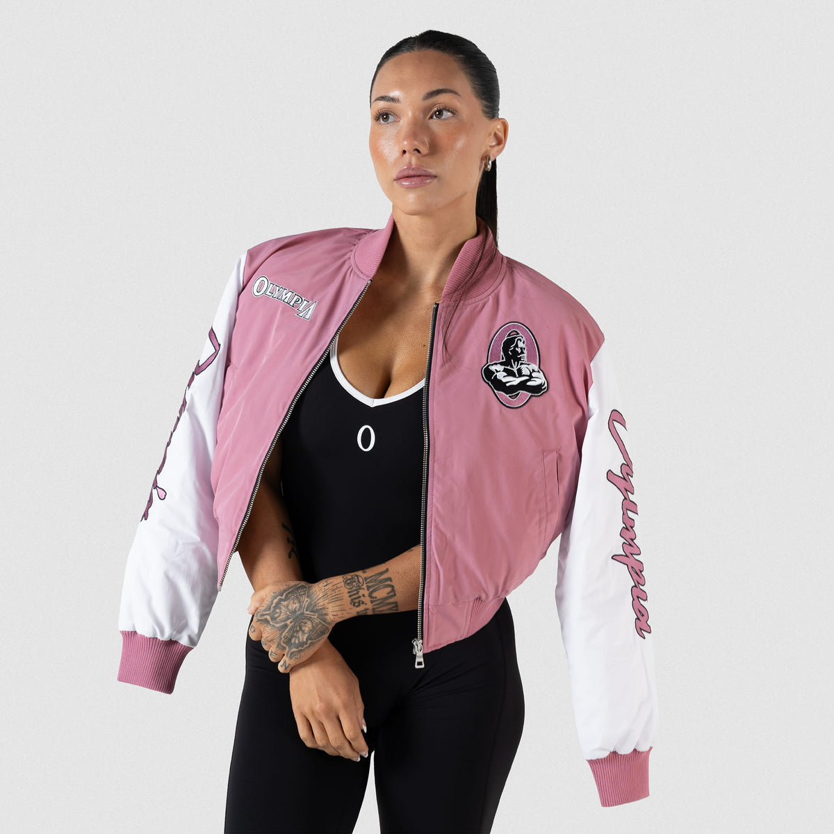 Model wearing the pink and white Rose Division Crop Bomber Jacket over her shoulders