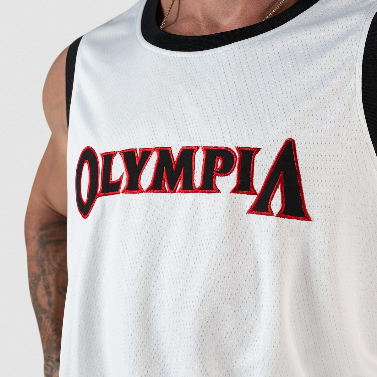 Signature Jersey | close up view of white mesh jersey and "Olympia" wordmark logo in black, with red border, across the chest