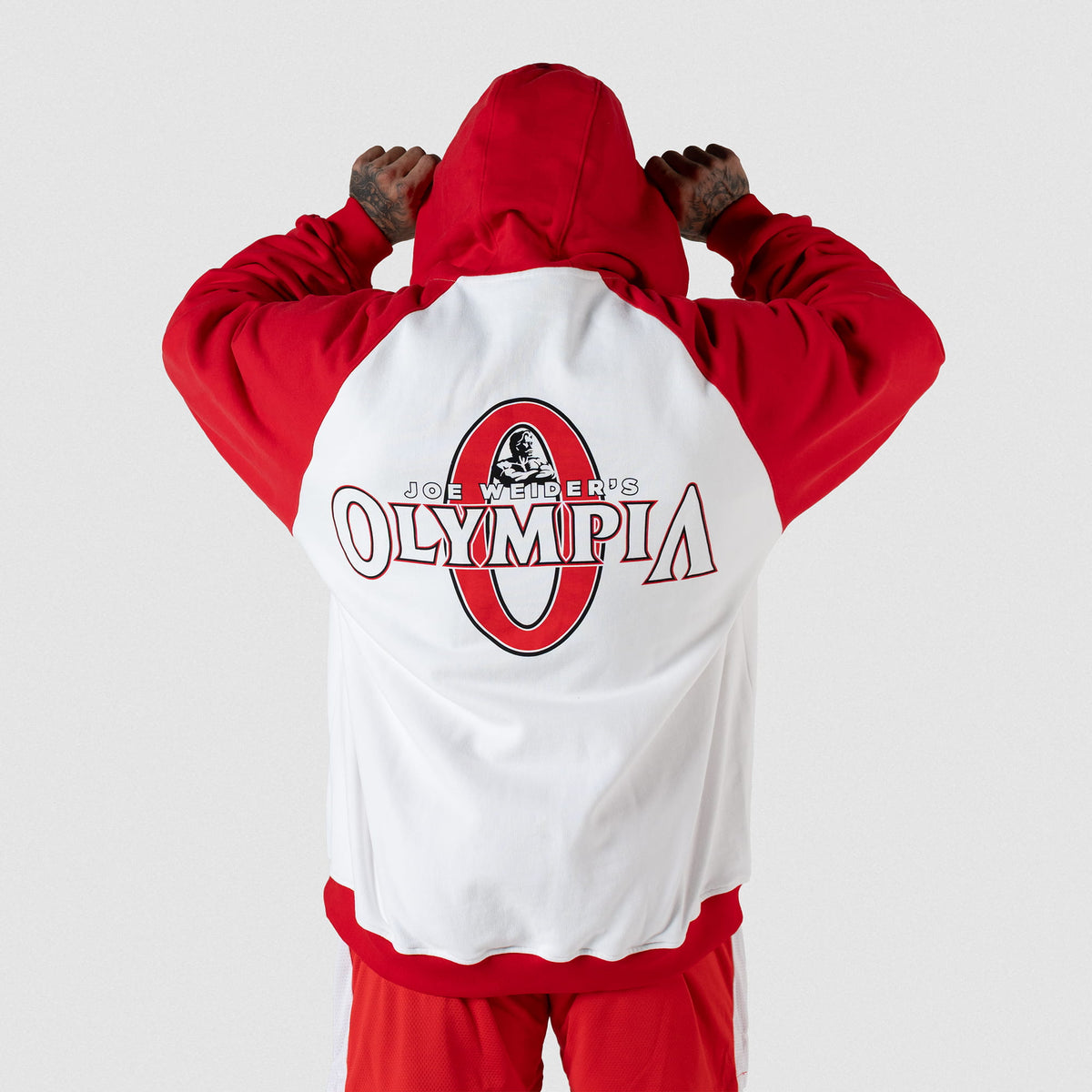 Signature Zip-Up Hoodie | Male model facing away to show back graphic on white hoodie fabric of official Signature Olympia logo in red and white