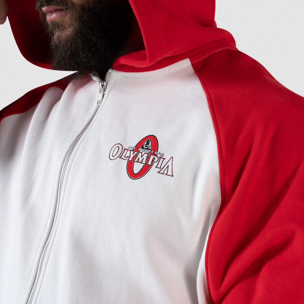 Signature Zip-Up Hoodie | Close up of small red and white chest graphic that says "Joe Weider's Olympia" with a large red O behind the white text