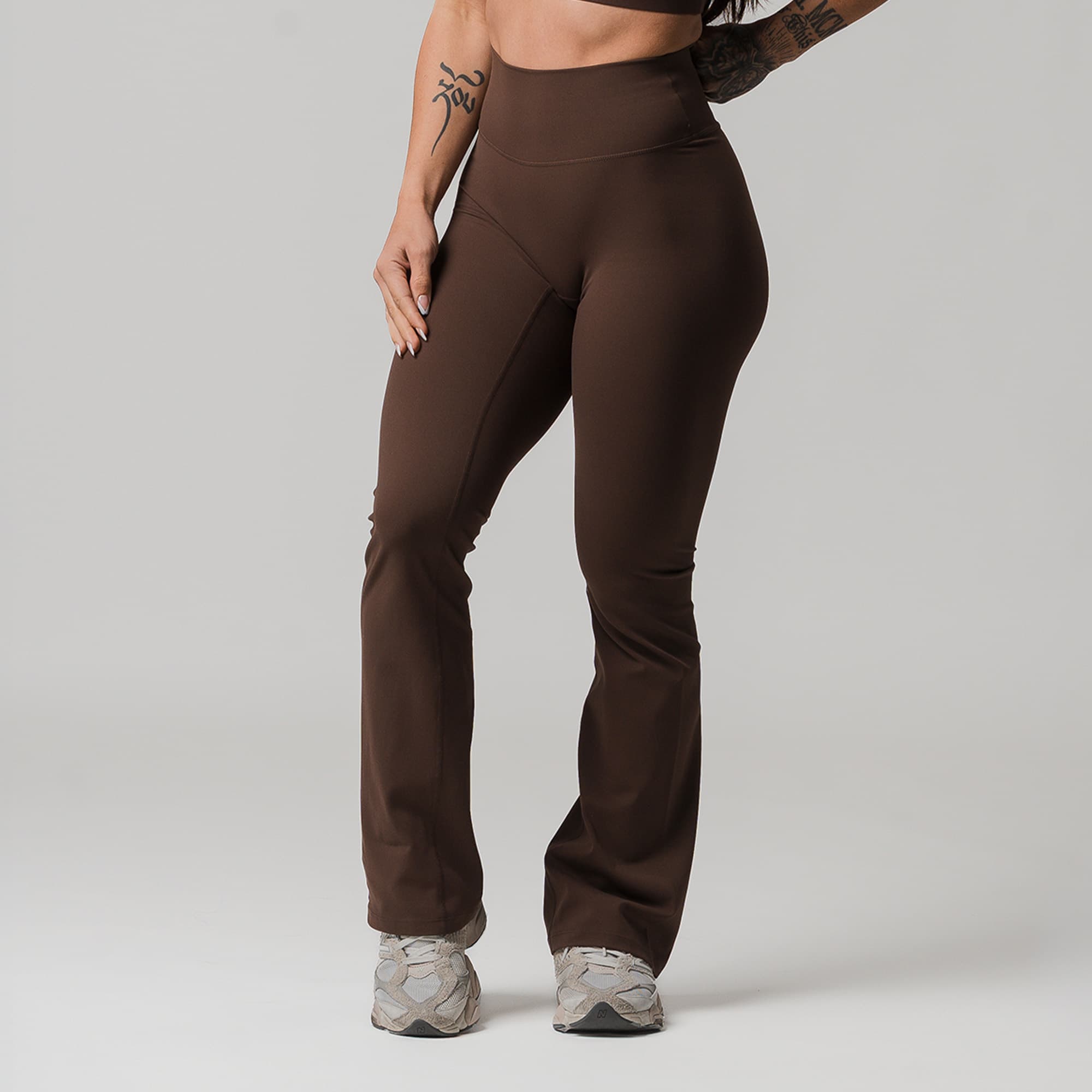 athlete wearing brown axis flare leggings half body shot front view