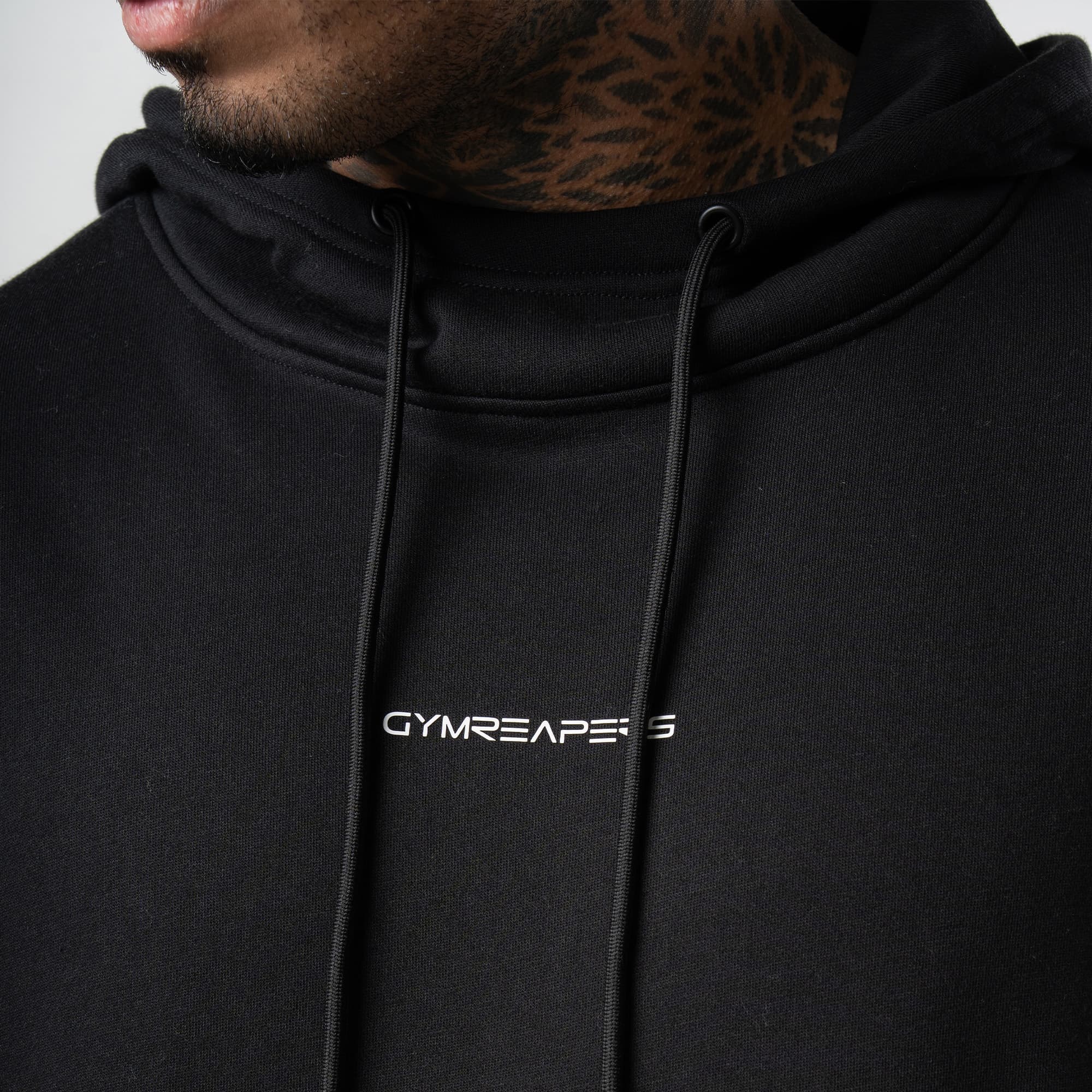 athlete wearing black/white axis mockneck hoodie close up detail shot of logo