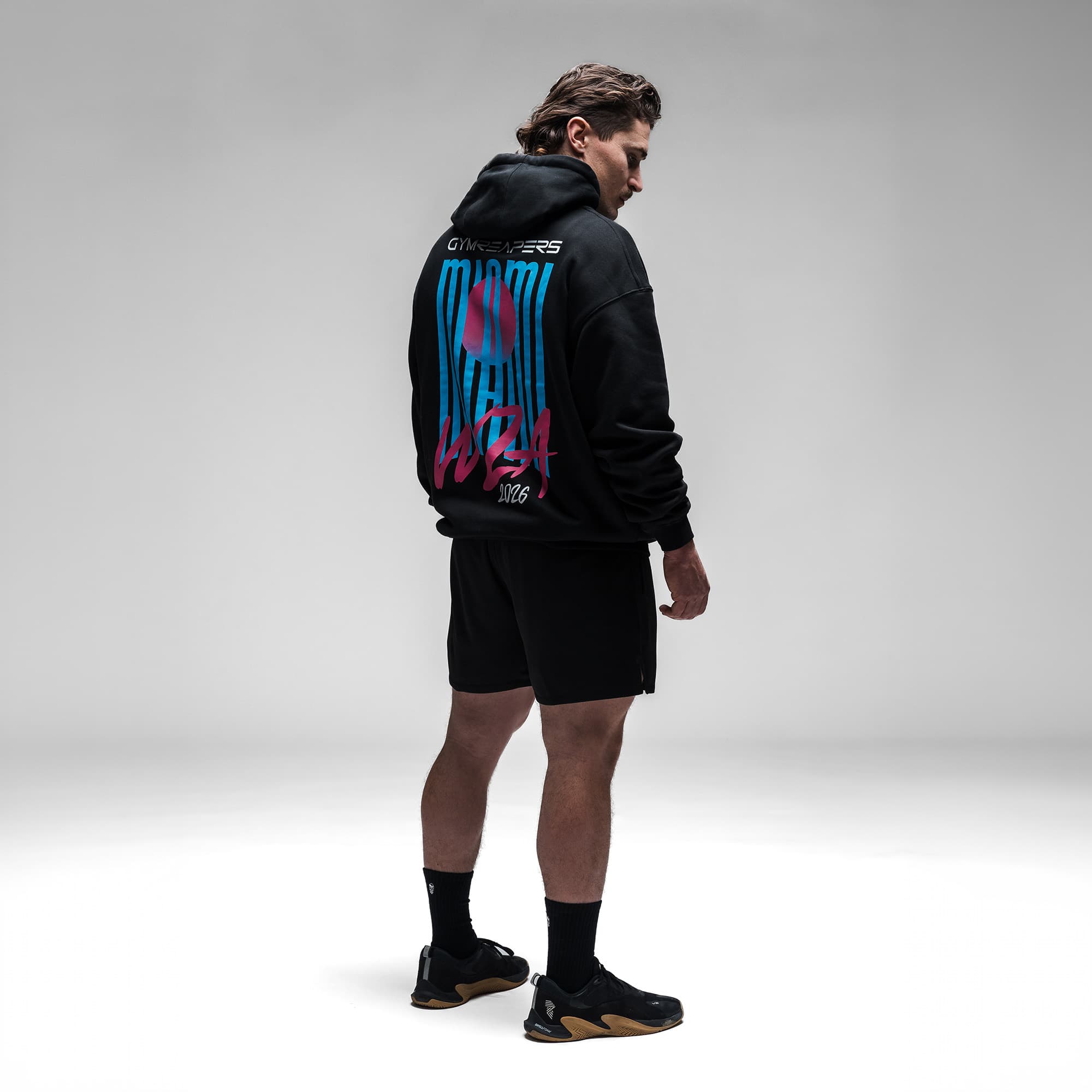 Male athlete wearing the Neon Horizon Hoodie full body shot back view