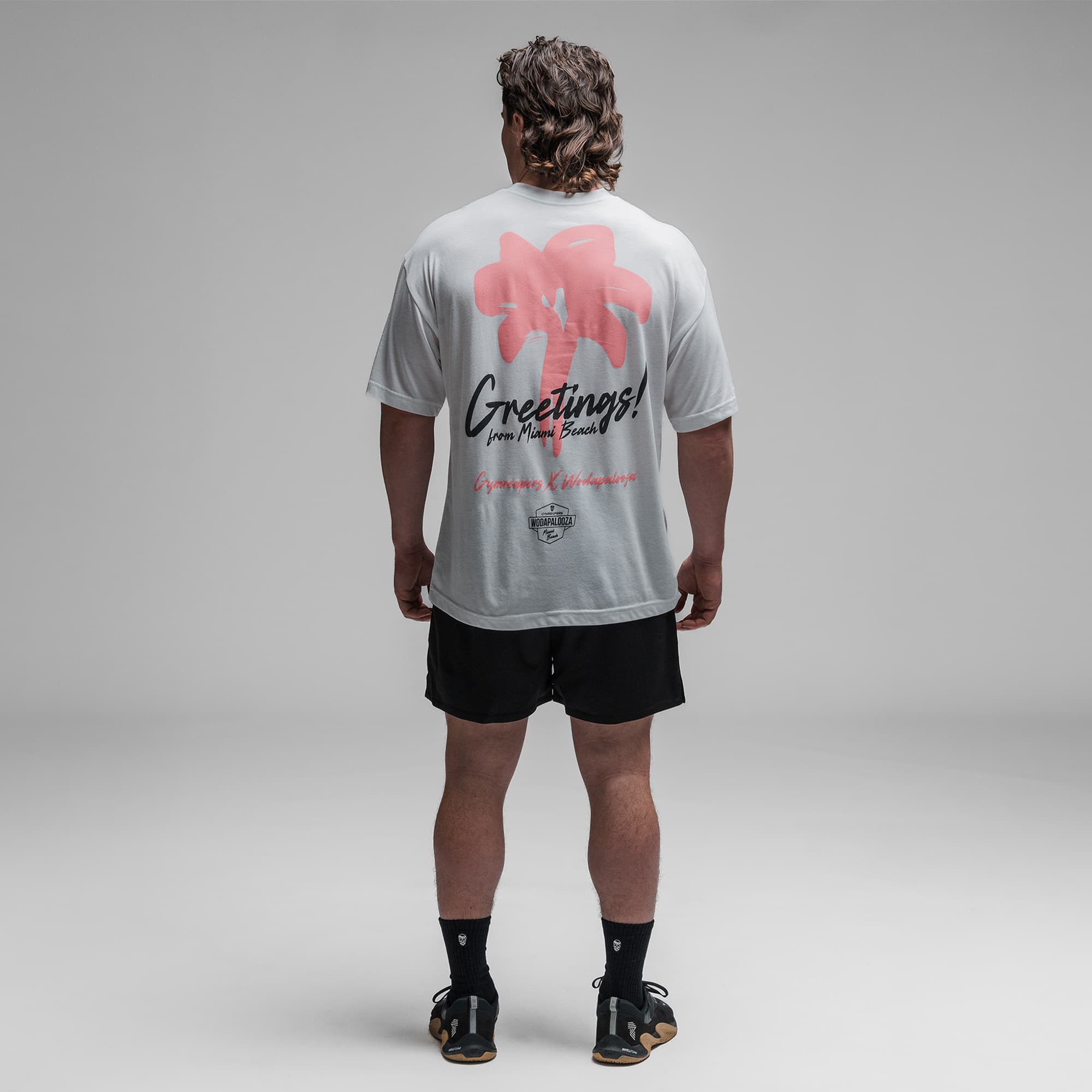 Athlete wearing the Greetings Tee full body shot back side