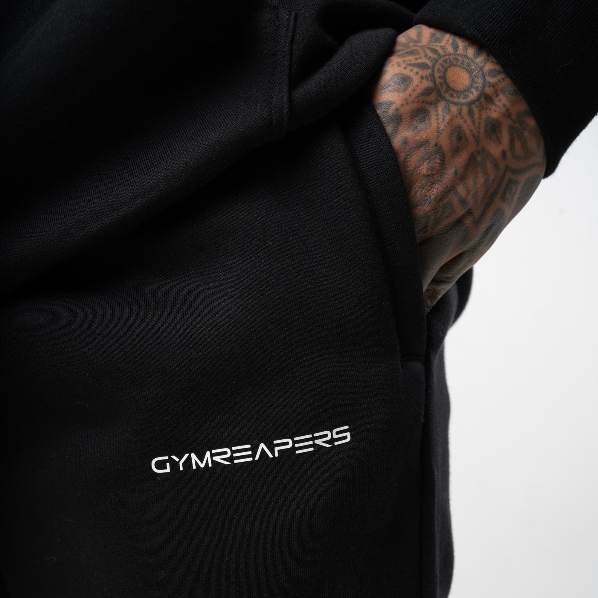 athlete wearing black/white axis joggers close up detail shot of logo
