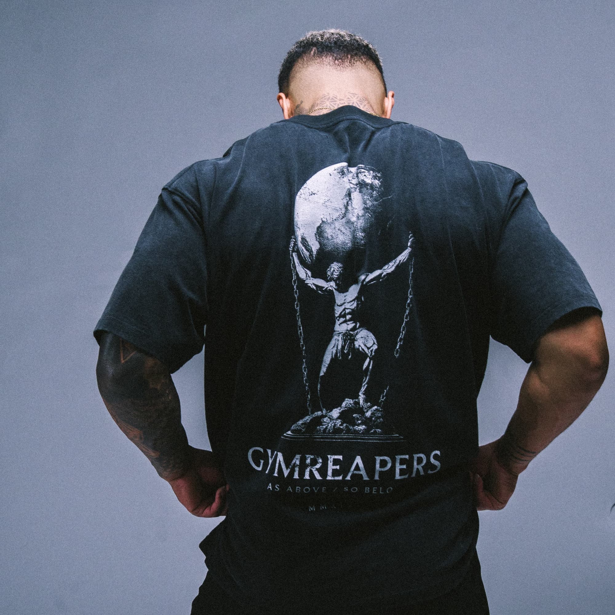 Athlete wearing the As Above So Below Graphic Tee in black, showcasing the full back print and oversized fit.