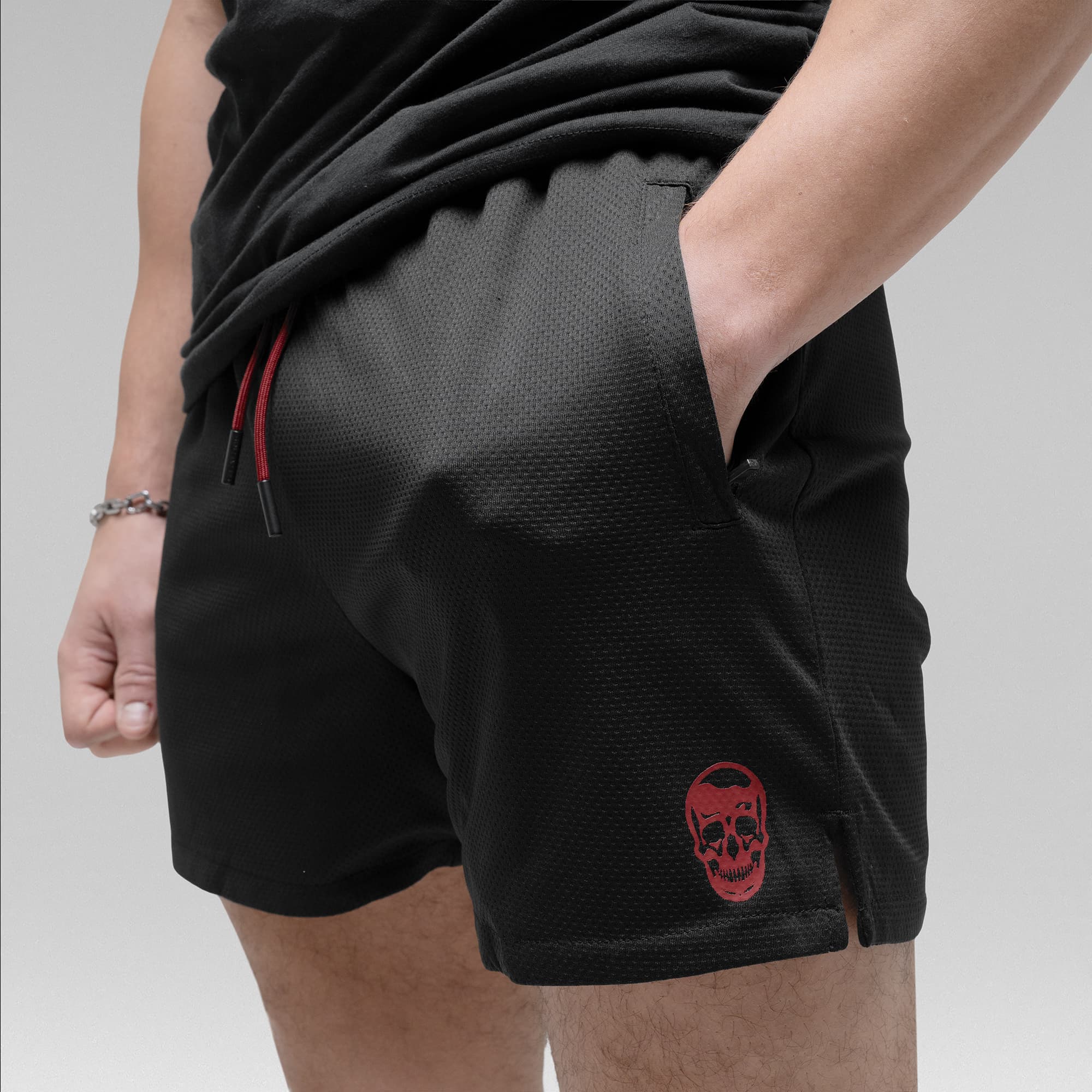 Athlete wearing the Black/Red Core Skull Mesh Training Shorts detail shot of pocket and logo