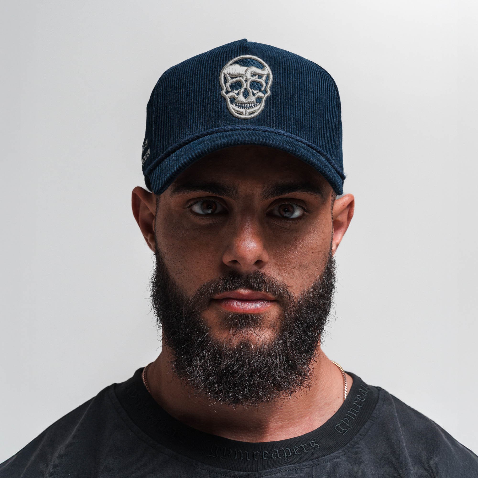 Athlete wearing Corduroy 5-Panel Skull Hat - Navy/Cream front view