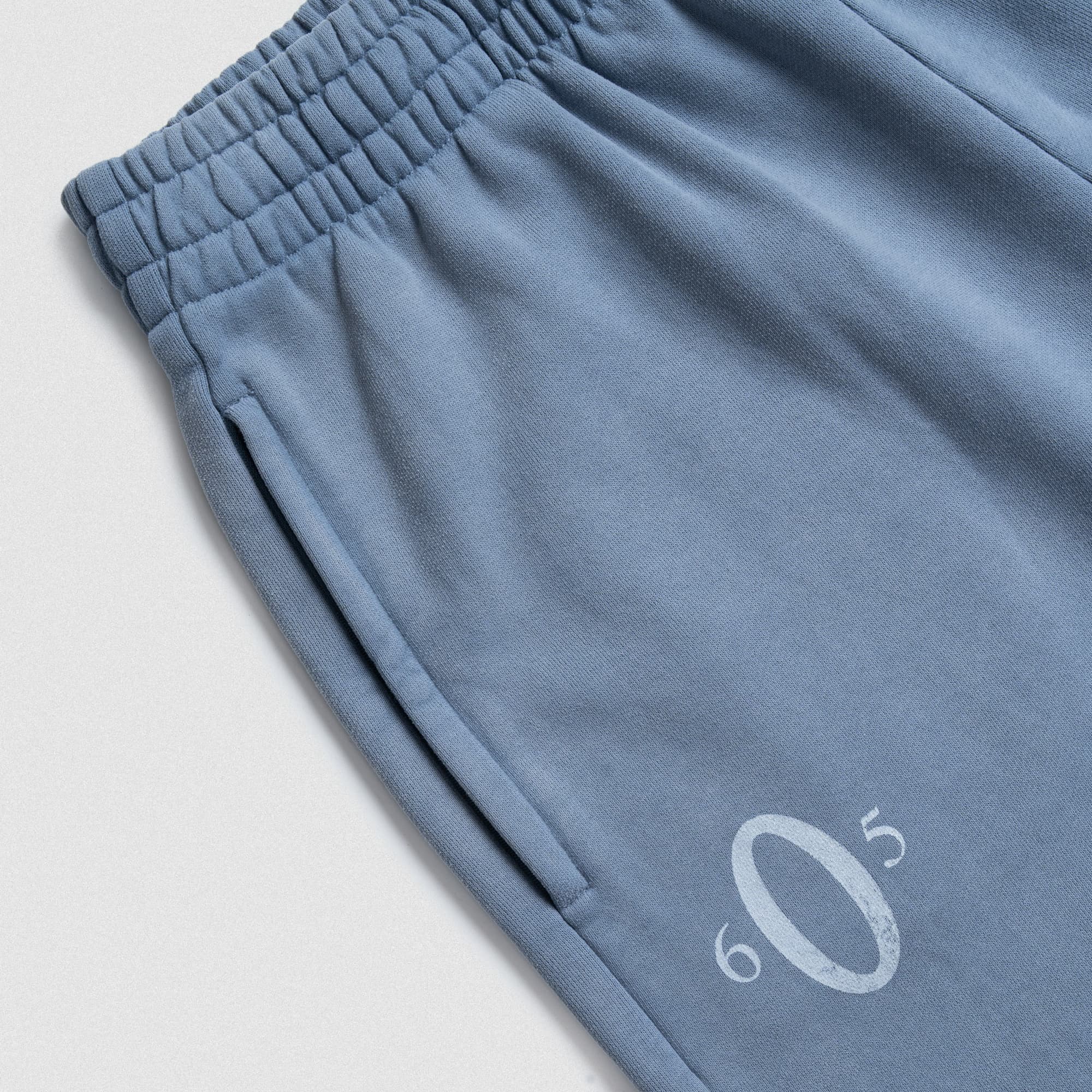 Close-up of waistband and pocket detail with O graphic