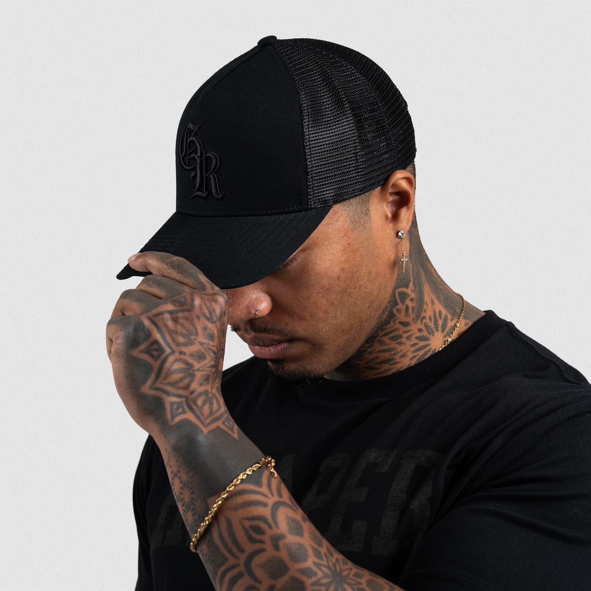 Athlete wearing Black/Black 5-Panel Initial Trucker Hat left side view