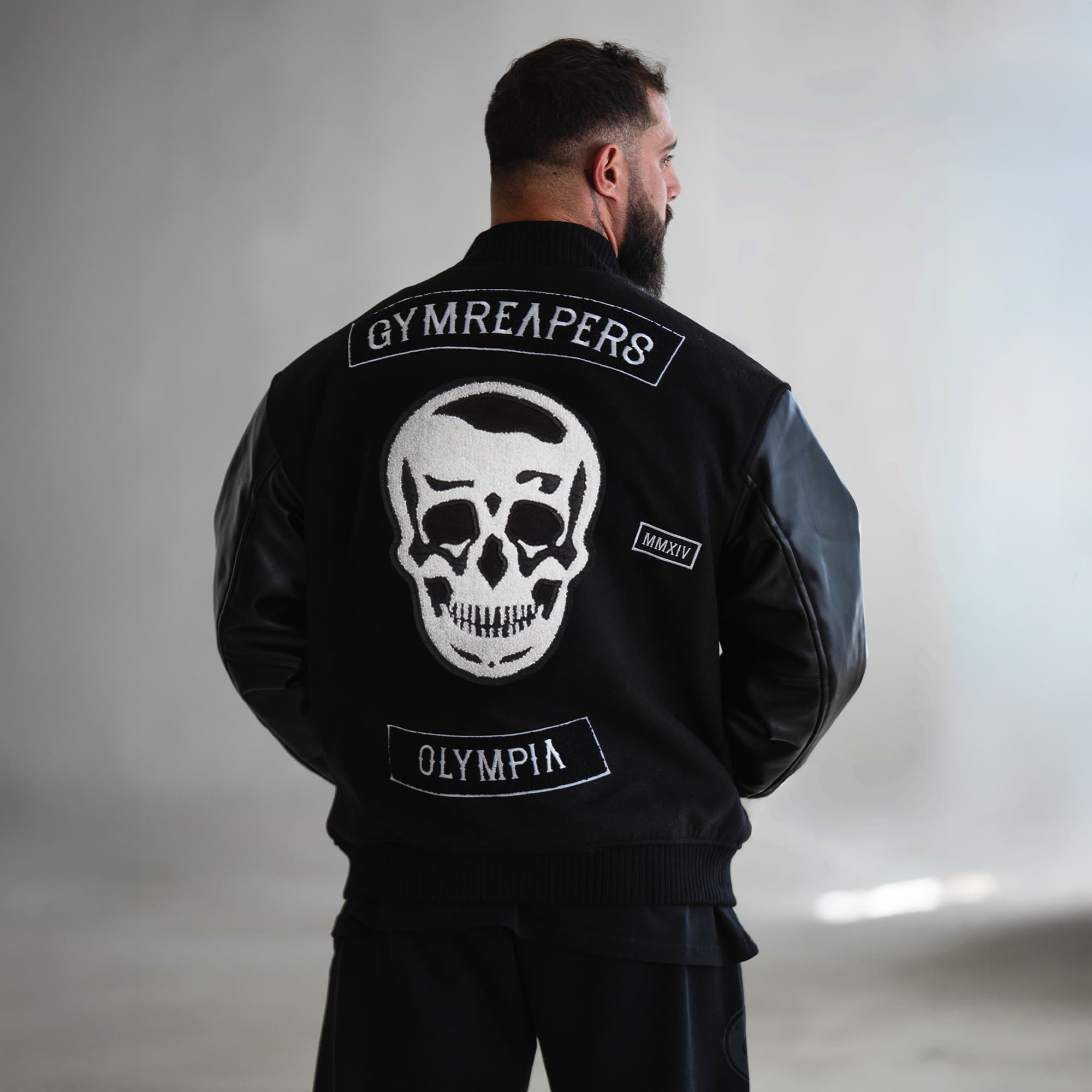 Model wearing the Gymreapers x Olympia Varsity Jacket back view