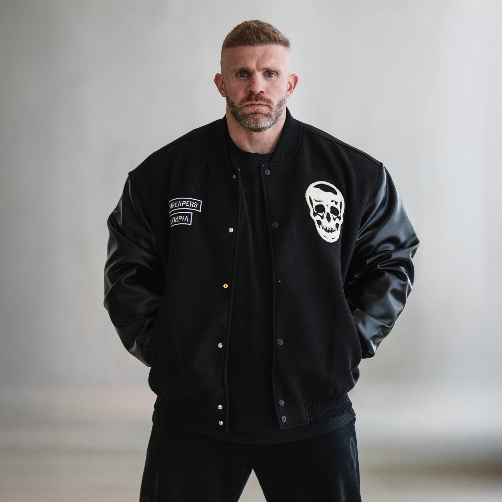 Model wearing the Gymreapers x Olympia Varsity Jacket front view