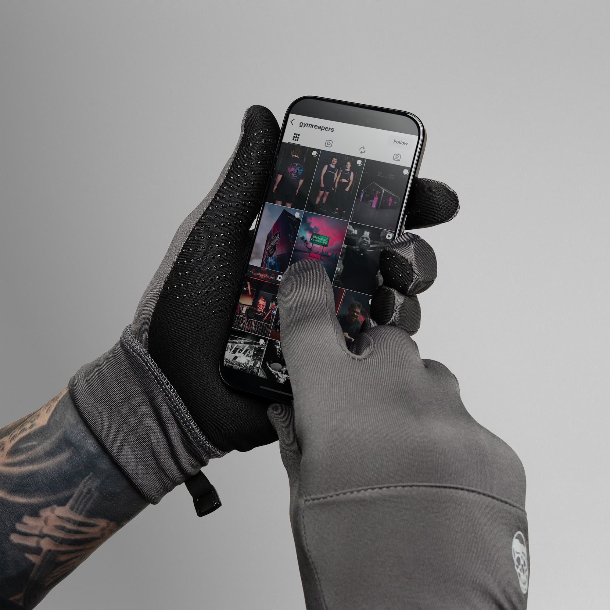 Model wearing Charcoal Stryda™ Run Gloves using phone showcasing touchscreen compatibility