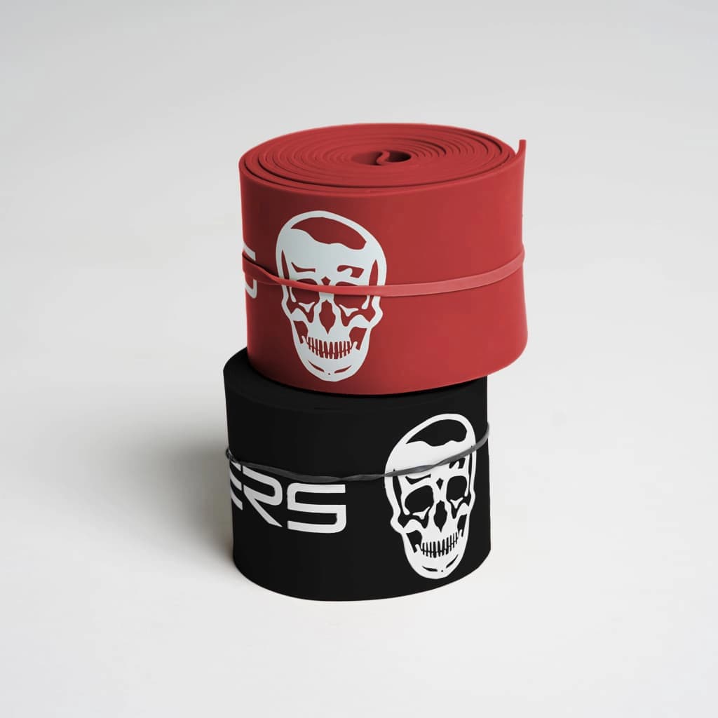 Photo of red and black floss bands 2 pack stacked on top of each other studio gray background 